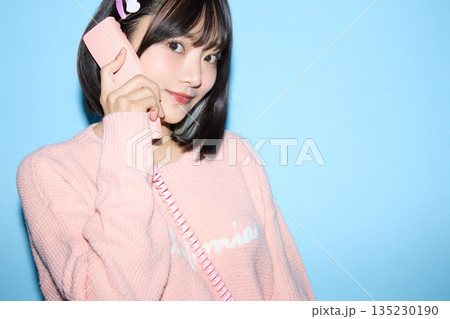 ブルー背景でかわいいポーズをする若いアジアの女性ポートレート 135230190