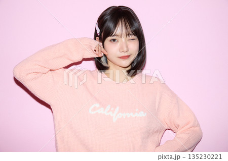 ピンク背景でかわいいポーズをする若いアジアの女性ポートレート 135230221