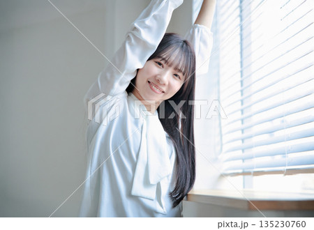 伸びをする20代女性のビューティーポートレート 135230760