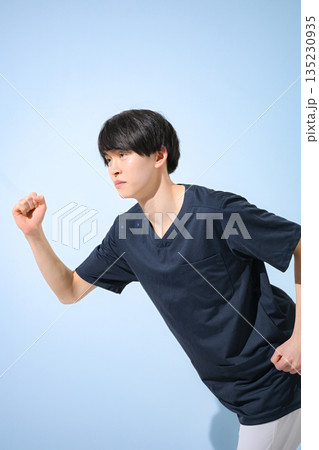 水色背景でスクラブを着た若い男性看護師や医師、スタートで走るポーズで笑顔就職や転職全身 135230935