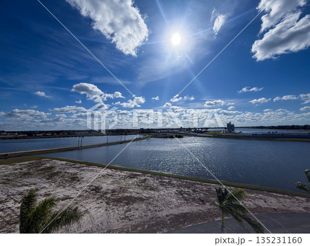 Bright Sun Over Coastal Lagoon and Blue Sky 135231160