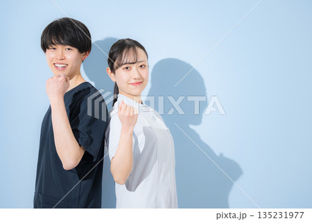 色背景で爽やかな看護師イメージの若い男女　新卒採用や転職の求人などに　ガッツポーズや頑張るぞ～ 135231977