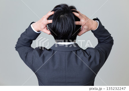 頭を抱えて悩むスーツ姿のミドル男性ビジネスマン 135232247