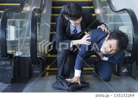 エスカレーター下で倒れるミドル男性 135232264