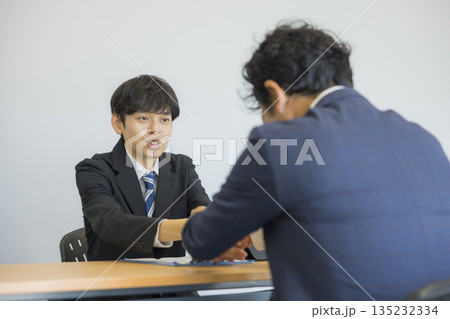 笑顔で話を聞くビジネスマン 笑顔で話を聞くビジネスマン 135232334