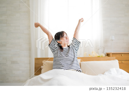 ベッドで伸びをする女性 135232418