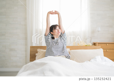 ベッドで伸びをする女性 ベッドで伸びをする女性 135232421