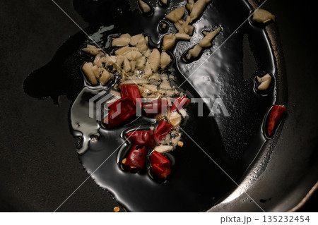 ニンニクと唐辛子をオリーブオイルで炒める様子 135232454
