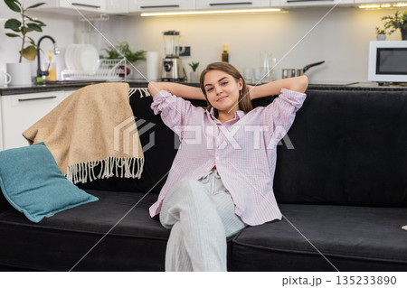 Young woman sits down to relax breathes deep and eases body and mind after long work with calm mood 135233890