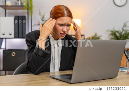 Young businesswoman spots debit credit error on laptop crumples paper throws it aside in panic today 135233922