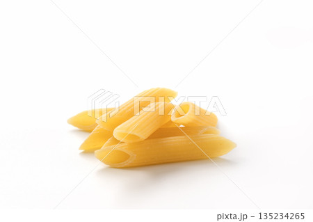 Italian dry penne rigate pasta over white background with shadow 135234265