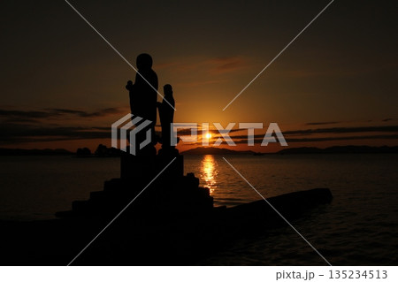 夕日に佇む仏像のシルエットと静かな宍道湖 135234513