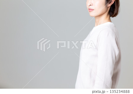 シンプルなカジュアルニット姿のミドル女性 135234888