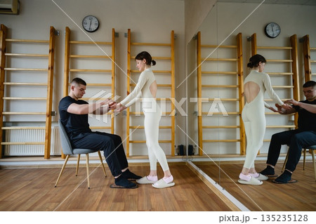 Trainer assisting man with nail standing practice indoors Trainer assisting man with nail standing practice indoors 135235128