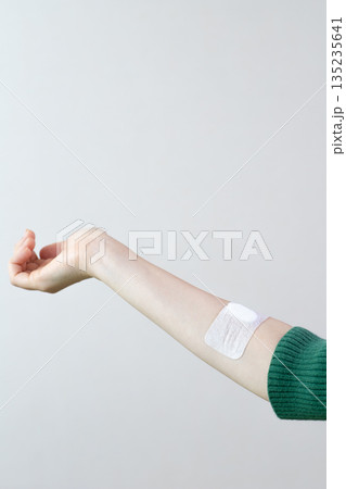 注射後に止血絆創膏を貼った女性の腕 注射後に止血絆創膏を貼った女性の腕 135235641