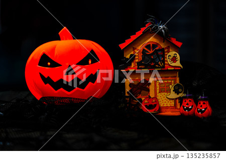 Plastic Pumpkin carved into spooky demon face for halloween 135235857