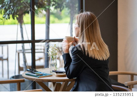 Tired thoughtful businesswoman on coffee break in cafe with notepad and smartphone, battling burnout Tired thoughtful businesswoman on coffee break in cafe with notepad and smartphone, battling burnout 135235951