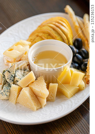 Cheese platter with honey pear and crackers 135236153