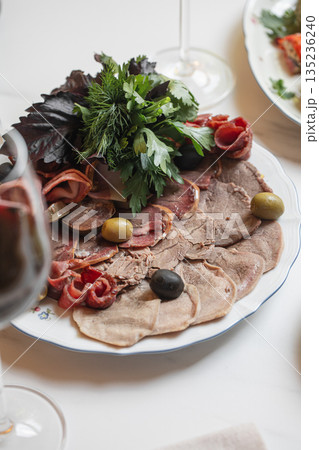 Cold meat platter with herbs olives and cured meat Cold meat platter with herbs olives and cured meat 135236240