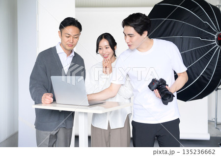 スタジオでノートパソコンを見て写真を確認する男女 135236662