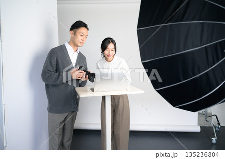 スタジオのパソコンで写真を確認する男女 135236804