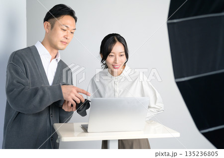 スタジオのパソコンで写真を確認する男女 135236805