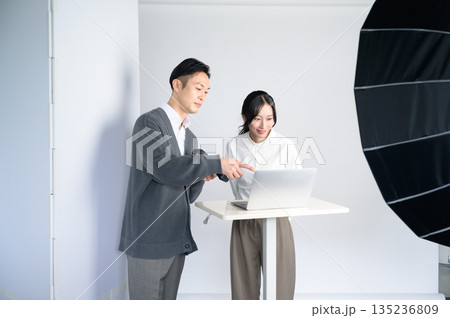 スタジオのパソコンで写真を確認する男女 135236809