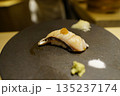 高級寿司店のモダンな一貫 薬味を添えたサワラの炙り握り 黒石皿盛り 135237174