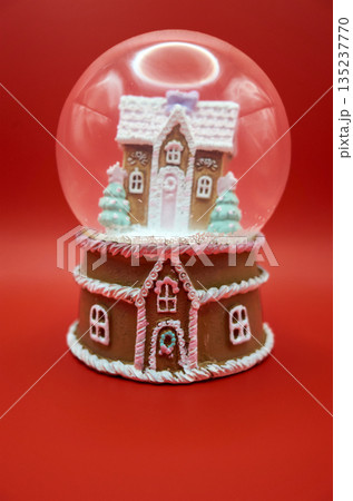 Miniature gingerbread cottage in transparent sphere with holiday details Miniature gingerbread cottage in transparent sphere with holiday details 135237770