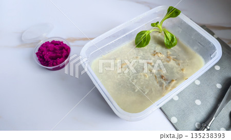 Cold meat jelly. Congealed broth in a transparent bowl. Horseradish next to it. Cold meat jelly. Congealed broth in a transparent bowl. Horseradish next to it. 135238393
