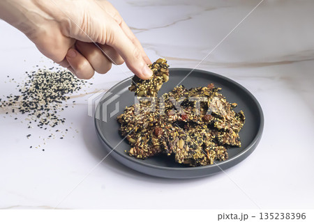 Crispy crackers made from chia, flax, sunflower, and pumpkin seeds, dried 135238396