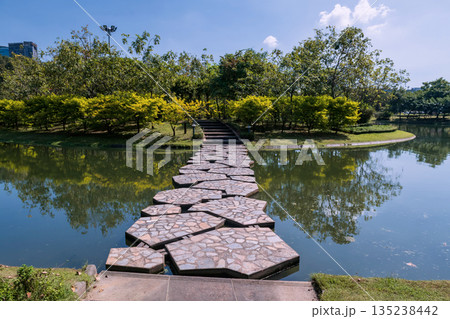 rock bridge cross pond with skyline reflection at Queen Sirikit park, Bangkok rock bridge cross pond with skyline reflection at Queen Sirikit park, Bangkok 135238442