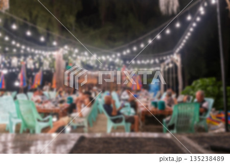Defocused image of people eating dinner at night, Trang Defocused image of people eating dinner at night, Trang 135238489