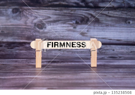 Firmness symbol. A wooden stick secured by Clothespins set over beautiful Realistic Wooden Texture Background. Business and Firmness concept with copy space 135238508