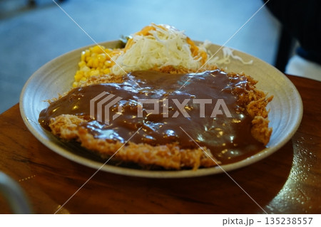 Delicious Tonkatsu with rich sauce, corn, and shredded cabbage on a plate 135238557