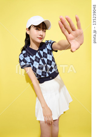 明るい背景でかわいいスポーツウェアを着た若い女性のポートレート 135239048