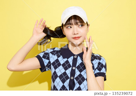 明るい背景でかわいいスポーツウェアを着た若い女性のポートレート 135239072