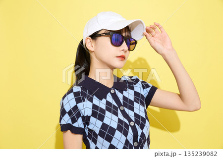 明るい背景でかわいいスポーツウェアを着た若い女性のポートレート 135239082