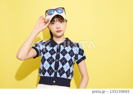 明るい背景でかわいいスポーツウェアを着た若い女性のポートレート 135239085