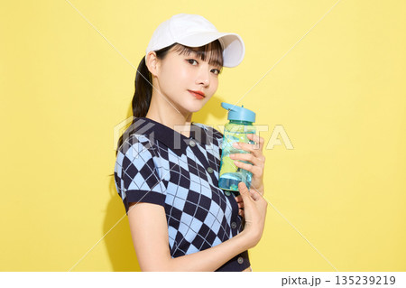 明るい背景でかわいいスポーツウェアを着た若い女性のポートレート 135239219