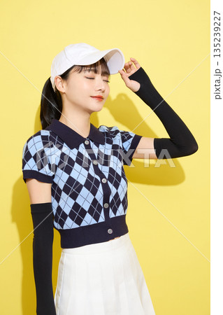 明るい背景でかわいいスポーツウェアを着た若い女性のポートレート 135239227