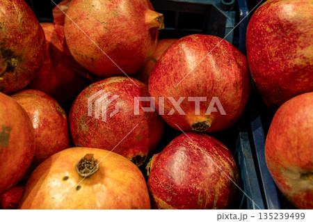 Fresh Red Pomegranates in Market Crate Highlighting Vibrant Produce and Juicy Flavor Fresh Red Pomegranates in Market Crate Highlighting Vibrant Produce and Juicy Flavor 135239499