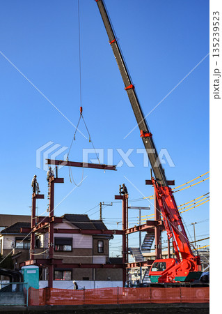 移動式クレーンで鉄骨を組む建設現場 135239523
