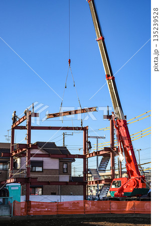 移動式クレーンで鉄骨を組む建設現場	 135239528