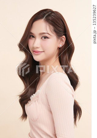 A beautiful young Asian woman with clean, fresh skin against a beige background. Skincare, facial treatment, cosmetology, beauty, and spa. An elegant portrait of an Asian woman. A beautiful young Asian woman with clean, fresh skin against a beige background. Skincare, facial treatment, cosmetology, beauty, and spa. An elegant portrait of an Asian woman. 135239627