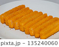 Closeup of fish fillet fingers on white plate. 135240060