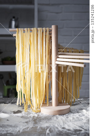 Homemade noodles hanging on wooden noodle dryer rack. Home cooking concept 135241286