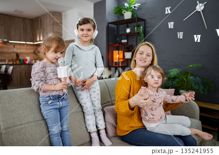 Mother and her three daughters have a karaoke party Mother and her three daughters have a karaoke party 135241955