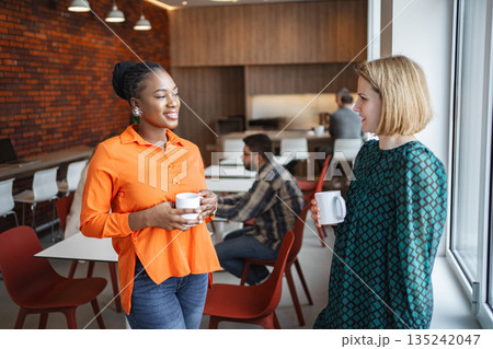 Two Women Standing Together with cup 135242047