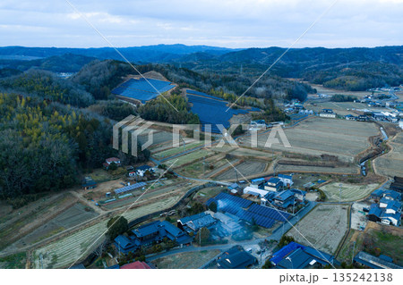 里山の斜面に広がる太陽光発電パネルと伝統的な集落 岡山県赤磐市 135242138
